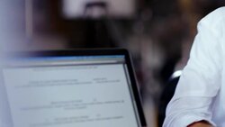 Restaurant employee studies day's menu on website Stock Footage