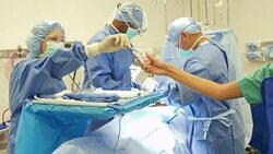 Nurse places medical specimen in container as surgeon uses sutures on patient Stock Footage