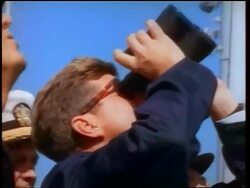 1960s close up PROFILE John Kennedy looking up with binoculars watching missile / naval officers around him Stock Footage