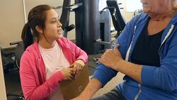 Physical therapist evaluates senior man's injury Stock Footage