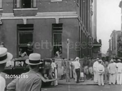 1929: LOUISIANA STATE MILITIA: Soldiers walking down sidewalk, WS (Across street) Soldiers turning corner w/ truck passing FG, VS Soldiers patrolling inside window, sitting w/ radio, sitting in window holding newspaper. Instructional Video