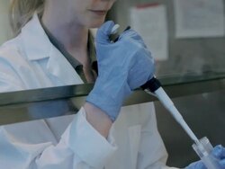 CU TU TD Female laboratory technician using micro-pipette in fume hood at Cancer research Healthcare medicine Industry DNA sequencing Laboratory / Vancouver, BC, Canada    Stock Footage