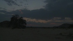 A distant sun dips behind a desert horizon. Stock Footage
