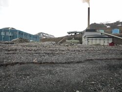 A stony beach and a power station in the back in Longyearbyen, Spitsbergen, Svalbard Stock Footage