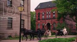Carriages and vehicles travel through an old town, 1908 - reenactment Stock Footage