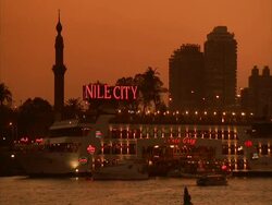 Locked off shot of River Nile, large boat below a neon red NILE CITY sign, Egypt (sound available) Stock Footage