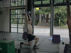 Medium frame profile. Casey performs series of overhead lunges. Stock Footage