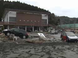 Destruction caused by tsunami after magnitude 9 Tohoku earthquake, north east Japan, March 2011. Cars lie wrecked in thick layer of mud in Ishinomaki City,  Miyagi Prefecture Stock Footage