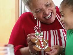 CU TU Grandmother and Granddaughter Decorating Gingerbread Men Cookies in Kitchen / Richmond, Virginia, USA Stock Footage