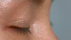 ECU Asian person blinking and closing brown eye Stock Footage