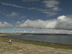 Pan left man walking Mansarovar Lake Lhasa Tibet China Stock Footage