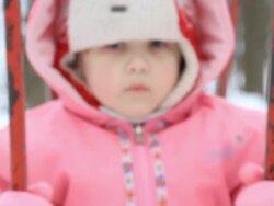 Little girl in red coat swinging at the swings Stock Footage
