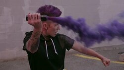 Cool young woman with purple mohawk holding purple powder cannon in martial arts fighting stance Stock Footage