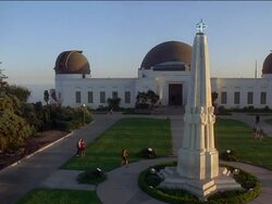 High angle wide shot people milling about the lawn and Astronomers Monument at Griffith Observatory / Los Angeles Stock Footage