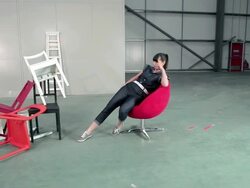 Young woman in swivel chair kicking pile of chairs over Stock Footage