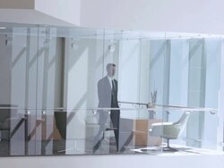  WS Businessman entering office and gazing out window, seen through interior windows / Seattle, Washington, United States Stock Footage