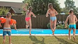 SLO MO DS Four kids jumping into the pool Stock Footage