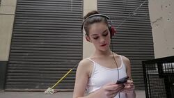 Cool young ballerina listening to music with headphones and mp3 player in urban alley Stock Footage