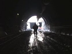 WS Construction worker walking through wet, muddy tunnel/ Slovenia Stock Footage