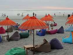 MS View of Some tourists relaxing beneath umbrellas on beanbags on beach at dusk / Seminyak, Bali, Indonesia Stock Footage