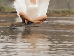 Young woman practicing yoga near waterfall, Athirappilly, Kerala, India Stock Footage
