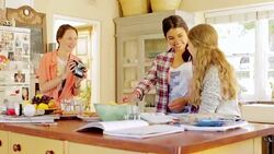 Teenage girls with instant camera in kitchen Stock Footage