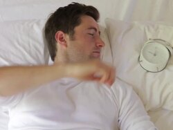 Man Being Woken In Bed By Alarm Clock Stock Footage