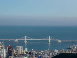 WS T/L View of haeundae (Popular travel destination) with Gwangan bridge viewed from top of mountain at sunset / Busan, Gyeongsangnam do, South Korea  Stock Footage
