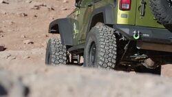 Medium low angle view of car driving on rocks in desert / Moab, Utah, United States Stock Footage