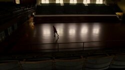 Sunlight illuminates a dark basketball court as an athlete practices shooting three-pointers. Stock Footage