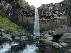 MS shot of river below Svartifoss waterfalls, hanging hexagonal basalt columns underlying / Skaftafell National Park, Austur-Skaftafellssysla, Iceland   Stock Footage