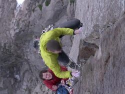 MS ZO ZI Shot of male climber climbing rock and man below holding rope with climber struggling to hold onto wet rock / Estes Park, Colorado, United States Stock Footage