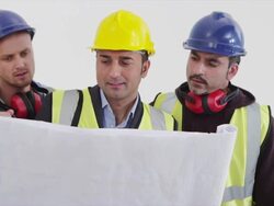 Construction workers examining blueprint Stock Footage