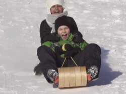 Boy and girl have fun sledding Stock Footage
