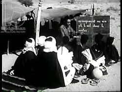 French man teaches French to Tuareg children at a Bedouin camp in Algeria, 1957 Stock Footage