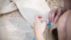 Hands sewing the natural material fabric Stock Footage