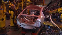 Robotic arms weld on cars on an assembly line. Stock Footage