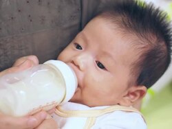 Baby infant suckling milk from bottle Stock Footage