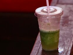 Plastic cup with green drink and staw Stock Footage