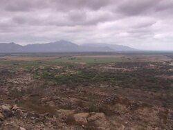 "Remains of ruined hillside dwellings in foreground, leading to flatlands and fields, jagged mountain range in background, cloudy sky, Lambayeque Valley, Peru [PerÃƒÂº]" Stock Footage
