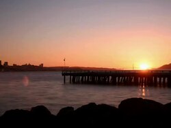 Sunset with Dock, Buildings, and Rocks Stock Footage