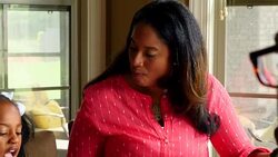 MS PAN Smiling young girl eating breakfast with family in home Stock Footage