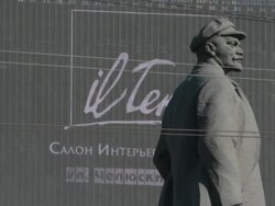 Lenin statue with moving image billboard depicting commercialism in background Stock Footage