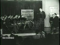 MOT 1946: JUILLIARD SCHOOL: Angled WS BEHIND Small group of people walking up building steps, TD MS People walking on & over 'Juilliard' door mat, 'King of Swing' Benny Goodman (1909-1986) standing on stage behind lectern w/ young adults seated on stage Instructional Video