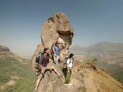 Three rock climbers standing on the cliff of a mountain Stock Footage