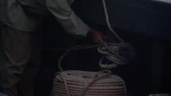 A sailor handles ropes at the side of a ship. Stock Footage