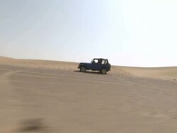 Long Shot tracking-left - A Jeep drives over the vast flat Sahara Desert sands / Sahara Desert, Egypt Stock Footage