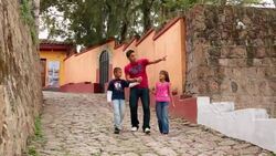 Hispanic teenage brother walks hand-in-hand, points out something to younger siblings Stock Footage