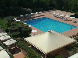 Vacationers enjoying a resort swimming pool; aerial view Stock Footage