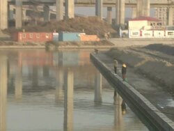 Extreme Long Shot pan-left tilt-up zoom-out - Fishermen fish in a waterway near highway overpasses./Shanghai, China Stock Footage